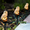 Load image into Gallery viewer, owl solar light beside a path in a garden that have been placed on stake to elevate them off the ground